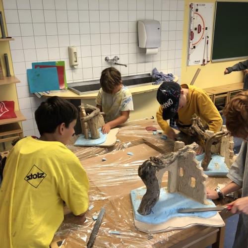 Schüler_innen beim Krippenbau mit Mitgliedern des Krippenbauvereins