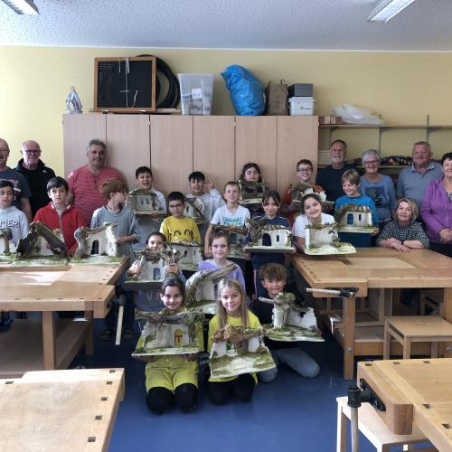Schüler_innen beim Krippenbau mit Mitgliedern des Krippenbauvereins