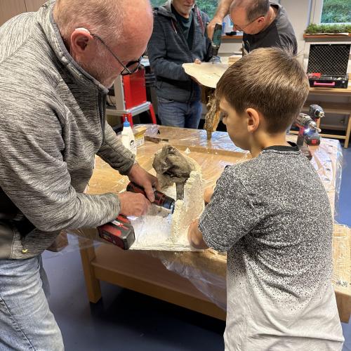 Schüler_innen beim Krippenbau mit Mitgliedern des Krippenbauvereins
